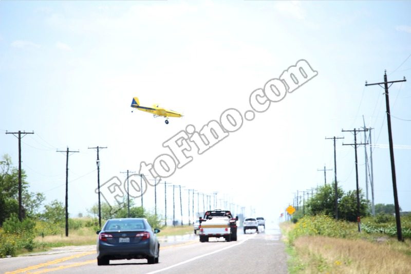 Crop Duster Flying Over Road - FotoFino.com